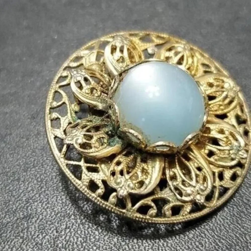 Vintage gold tone round brooch with blue